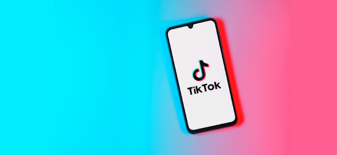 Illustration of a mobile phone showing the TikTok logo on a blue and pink background