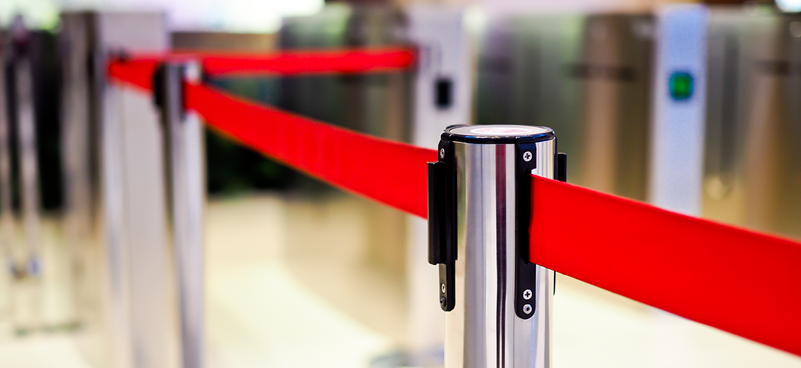 Red tape and chrome bollards for queueing lines.